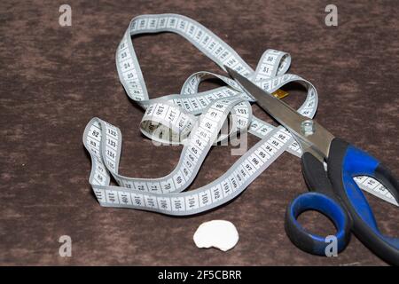 Tailor's desktop background, with tape measure, chalk and scissors Stock Photo