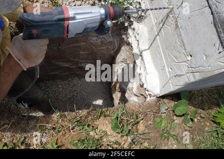 Drilling a hole in the concrete wall with a jackhammer, perforator in operation.new Stock Photo
