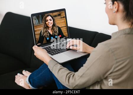 Back view of business latin woman talking to her mexican colleagues in video conference business team using laptop for a online meeting in video call Stock Photo