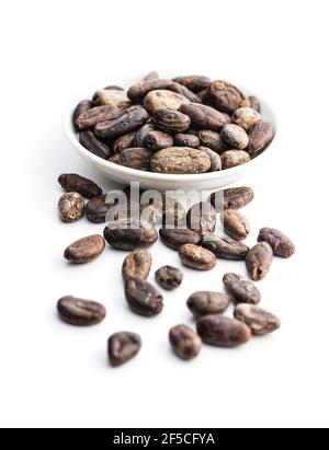 Roasted cocoa beans in bowl isolated on white background. Stock Photo