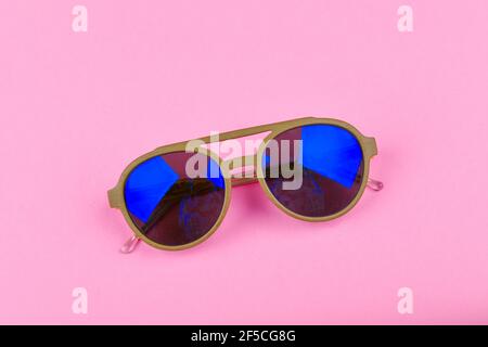blue glasses on a pink background. Glamor and style. Glasses for women. The apartment was lying. A place to write. Advertising studio shot of pink gla Stock Photo