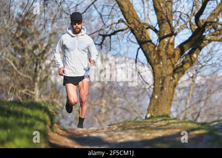 Young man running athlete during a workout in a hill Stock Photo