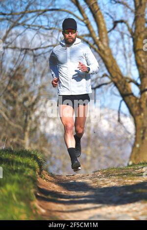 Young man running athlete during a workout in a hill Stock Photo