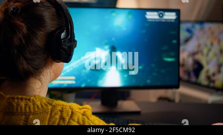 Back shot of pro gamer playing online shooter game on computer using  wireless controller. Competitive player man winning videogame tournament  use professional equipment at home gamming studio Stock Photo - Alamy