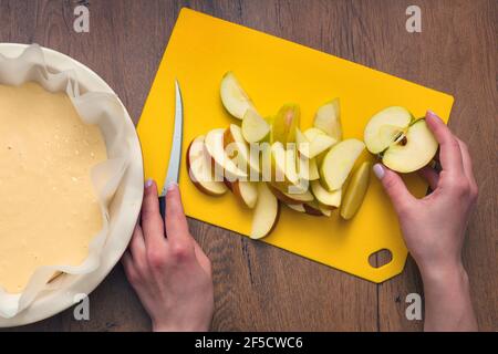 The hostess at home is preparing apple charlotte in the kitchen. puts ingredients on apple pie Stock Photo