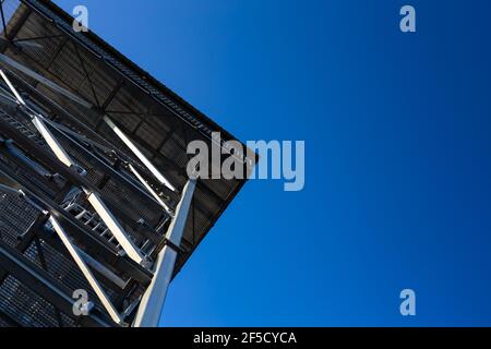 A view of the top of the steel observation tower. The object against the blue sky Stock Photo