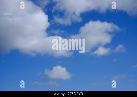 fluffy white clouds on bright blue sky background Stock Photo