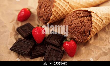 Chocolate ice cream in a waffle cone on craft paper background Stock Photo