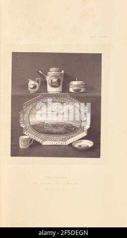Cabaret. A tea service with a tray, coffee pot, milk pot, sugar pot, and cup and saucer. Each piece of the service is decorated with a painted landscape inside a medallion surrounded by patterned borders. The tray features a speckled background.. (Recto, mount) upper right, printed in black ink: "PLATE CXXXV." Lower center, printed in black ink: "COPENHAGEN. / 270. CABARET. WITH LANDSCAPES. / Mr. Walker Joy. italicized" Stock Photo