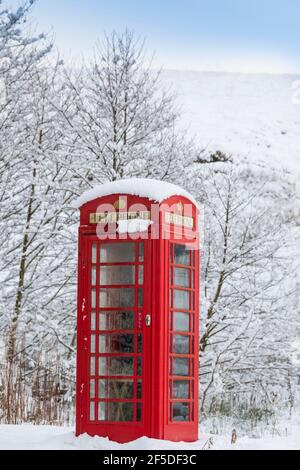 Kirkby Stephen, Cumbria, UK, 9th January 2020. A red phone box stands out among the snow in an isolated rural community, Outhgill, in Mallerstang near Stock Photo