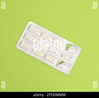 rectangular pieces of gum in a blister pack on a green background, close up Stock Photo