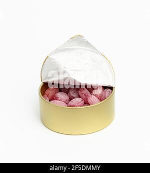fruit oval lollipops in an open round tin can on a white background, close up Stock Photo