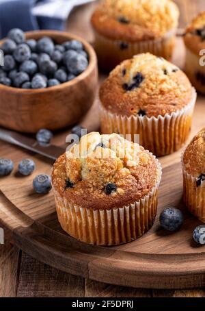 Delicious blueberry muffins with fresh berries on a rustic wooden platter Stock Photo