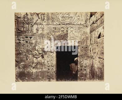 Egypte. sic Bas relief dans la 2eme cour á droite du temple de Ramessès. A native man stands by the opening of a wall that is carved with hieroglyphs.. (Recto, print) lower right, inscribed in the negative: '218 space Egypte. sic Bas relief dans la 2eme sic, 'eme' in superscript cour · sic droite du temple de RamessËs'; Stock Photo