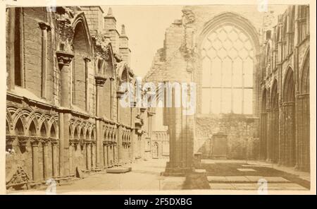 Ruins of Holyrood Abbey. Interior of the ruins of Holyrood Abbey. A wall with a large arched window still stands, the window tracery also still intact. The tracery forms ten lancet windows, in two rows of five. A partial column stands in the center of the floor. Stock Photo