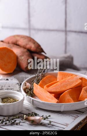 Raw sweet potato with herbs and garlic Stock Photo - Alamy