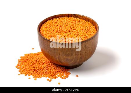 Raw seeds of orange lentils in wooden bowl, spoon isolated on white background Top view Flat lay Healthy eating, vegetable protein concept Traditional Stock Photo