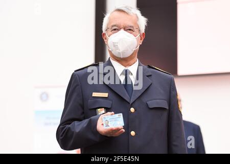 26 March 2021, Bavaria, Roding: State police chief Wilhelm Schmidbauer holds his new service ID card at a press event. After 35 years, the old green service cards are being replaced by a new, particularly forgery-proof card in cheque card format. Photo: Tobias Hase/dpa Stock Photo