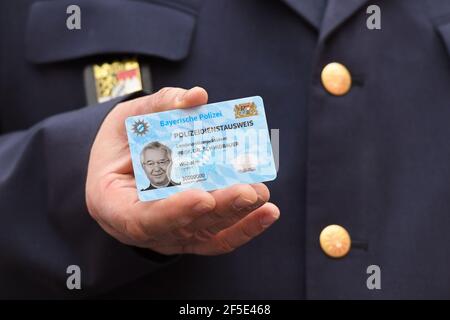 26 March 2021, Bavaria, Roding: State police chief Wilhelm Schmidbauer holds his new service ID in his hand at a press event. After 35 years, the old green service cards are being replaced by a new, particularly forgery-proof card in cheque card format. Photo: Tobias Hase/dpa Stock Photo