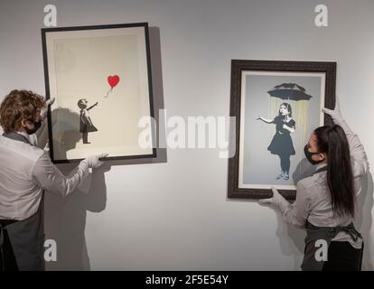 Christie's, London, UK. 26th Mar, 2021. The Prints & Multiples and Banksy: I Can't Believe You Morons Actually Buy This Sh*t Online Sales preparations take place behind closed doors. Image: (left) Banksy, Girl with Balloon, estimate: £300,000-500,000; (right): Banksy, NOLA (Yellow Rain) - Outside of the edition screenprint in colours with a hand-applied red sticker, 2008, on wove paper. Estimate: £200,000-300,000 Credit: Malcolm Park/Alamy Live News Stock Photo