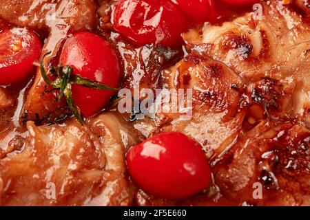 Food background close-up homemade baked chicken thighs with soy sauce and tomatoes. Selective focus. Top view Stock Photo