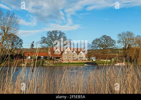 Typical gable fronted brick & flint house and reeds by the River Thames near Mill End Lock; Mill End, Hambleden, Bucks, UK Stock Photo