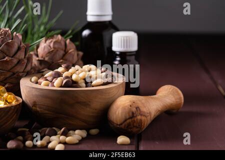 natural product cedar nut oil with glass bottles and cones on a wooden table Stock Photo