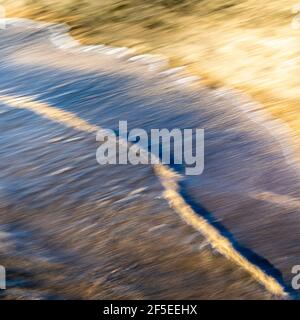 abstract landscape of sea. texture water and sand in blurry motion in the golden hour Stock Photo