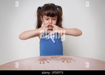 Allergy to dust in a child. Girl covering her nose Stock Photo