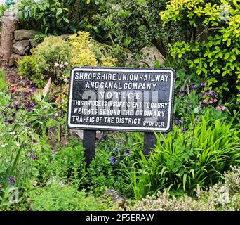 An old cast iron sign saying that a bridge is insufficient to carry large weights, next to the Shropshire Union canal, Gnosall, Staffordshire, England Stock Photo