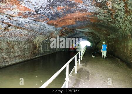 A woman walking her dog through Cowley Tunnel on the Shropshire Union canal, Gnosall, Staffordshire, England, UK Stock Photo
