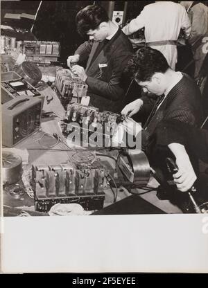 Two young men wearing blazers work on radios. Arnold Eagle (American, 1909 - 1992) Stock Photo