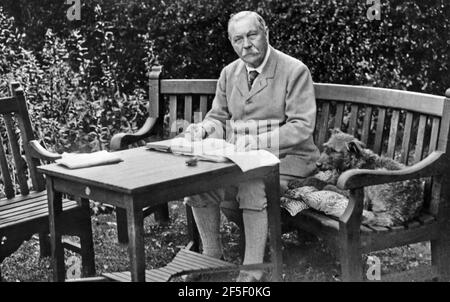 ARTHUR CONAN DOYLE (1859-1930) Scottish physician and fiction writer, creator of Sherlock Holmes with his Irish Terrier/Airedale cross Paddy about 1927 at his home Bignell Wood in the New Forest Stock Photo