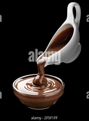 Pouring melted chocolate on black background Stock Photo