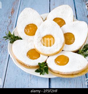 Small Easter shortbread muffins, filled with custard cream and sprinkled with powdered sugar. Stock Photo