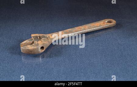 A rusty wrench lies on the table with the reflection. Locksmith tools on a black background Stock Photo