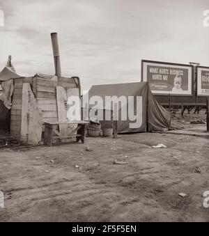 Squatter camp on the flat where families live during the orange picking season. Near Porterville, California. February 1938. Photograph by Dorothea Lange. Stock Photo