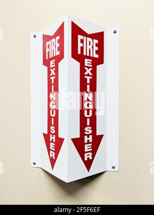 Angled two sided fire extinguisher arrow sign on wall Stock Photo