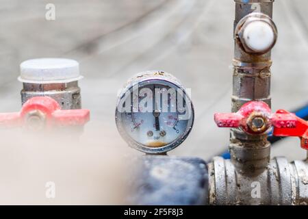 Rusty old pressure gauge in the water supply system close up Stock Photo