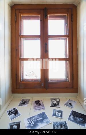 Black and white family photographs on white painted wood plank windowsill in office room on upstairs floor inside an old 1807 cottage style house Stock Photo