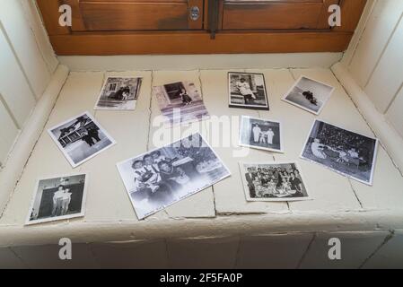 Black and white family photographs on white painted wood plank windowsill in office room on upstairs floor inside an old 1807 cottage style house Stock Photo