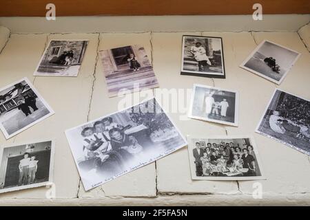 Black and white family photographs on white painted wood plank windowsill in office room on upstairs floor inside an old 1807 cottage style house Stock Photo