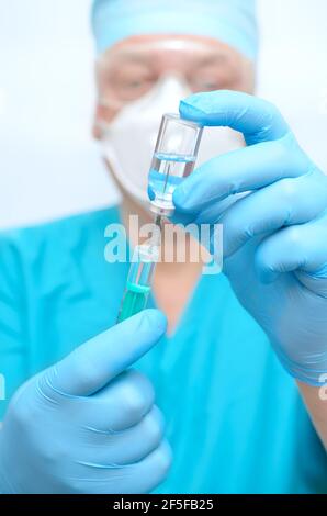 A medical professional is holding a syringe. Stock Photo