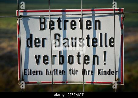 Sign on a fence with the inscription do not enter the construction site, parents are liable for their children Stock Photo