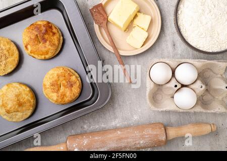 Homemade pies on a baking tray with ingredients. Stock Photo