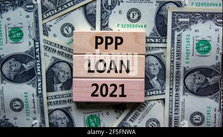 PPP, paycheck protection program loan 2021 symbol. Concept words PPP loan 2021 on blocks on a beautiful background from dollar bills. Business, PPP - Stock Photo