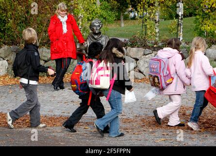 Portrait of the actress Inger Nilsson who played Astrid Lindgren's Pippi. Photographed at Djurgården in Stockholm. To the right the statue of Astrid Lindgren.Photo Jeppe Gustafsson Stock Photo