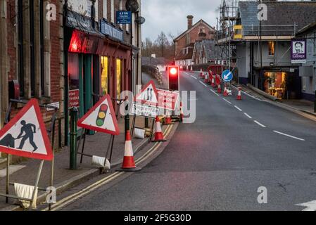 Roadworks with traffic control and traffic lights on red in a town centre street in the UK Stock Photo