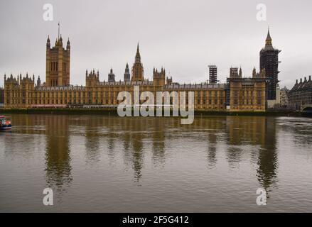 London, United Kingdom. 26th March 2021. Houses of Parliament reflected in River Thames on an overcast day. Stock Photo