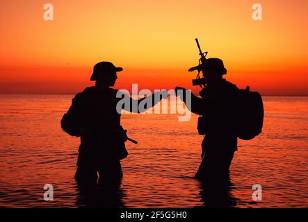 Silhouette of soldiers celebrating with fist bump gestures while ...